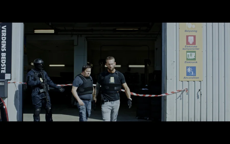 Gadens Melodi — Police characters leaving a cordoned-off garage