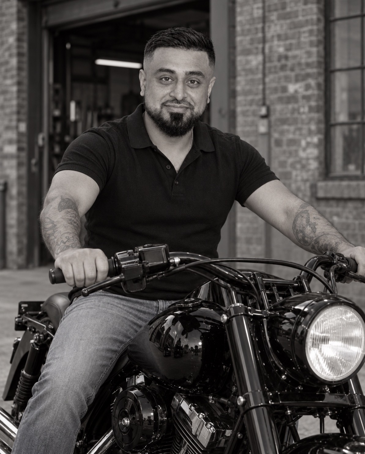 Omid Romal seated on his black Harley-Davidson