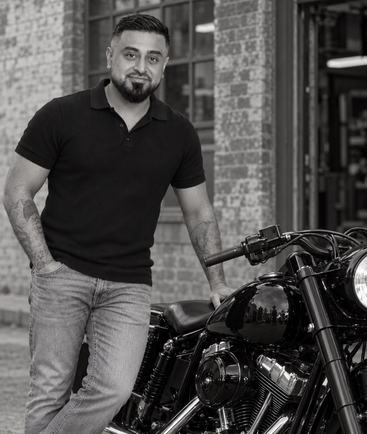 Omid Romal standing beside his motorcycle